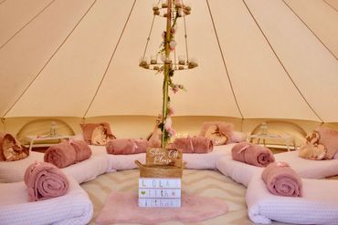 Boho Bliss bell tent with pink bedding and hanging vine chandelier.