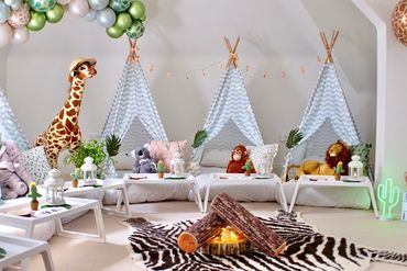 Safari themed children’s teepee sleepover setup with campfire centerpiece by Slumber Buddiezzz.