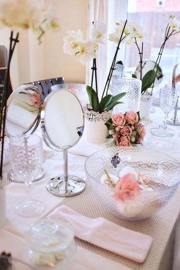 Beauty table with mirrors and fresh flowers.