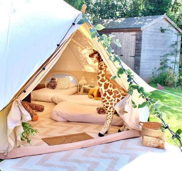 Into The Wild bell tent with safari theme and plush giraffe.
