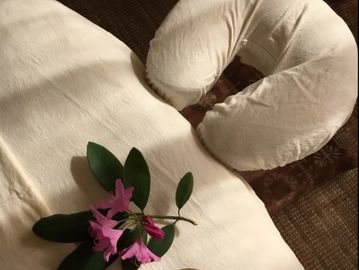 A massage table with a cushioned face cradle and a pink flower on the side.