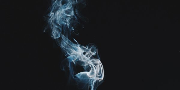 Image of a wisp of smoke on a black background. Photo by Damon Lam.