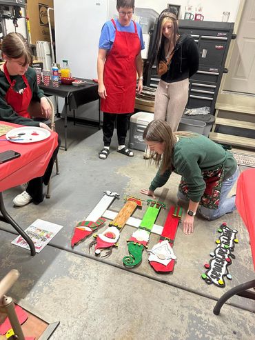 Four women working on Christmas gnome decorations in a workshop.