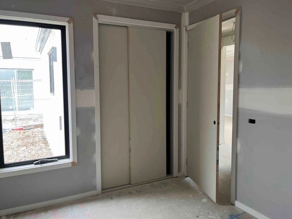 Unfinished room with sliding closet doors and a window.