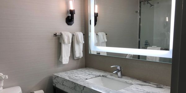Hotel remodeling after picture with new vanity and backlit mirror in bathroom