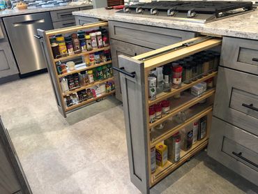Marietta, GA Kitchen Remodeling Company project picture of spice racks pulled out at cooktop area.