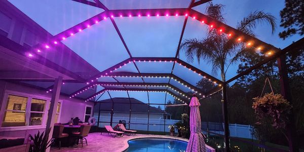 Colorful screen enclosure lighting on a Saint Johns County home by Glow Bug.