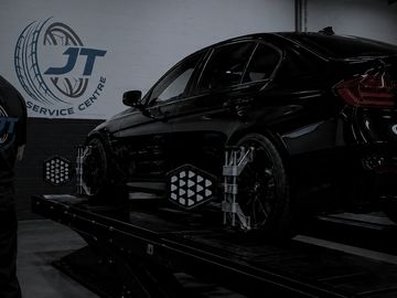 Black car on alignment platform at JT Service Centre.