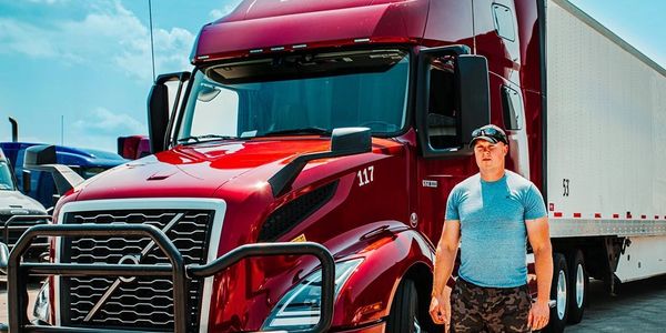 A TVA Logistics truck driver near his truck