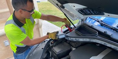 A man jump-starting a Mercedes car battery.
