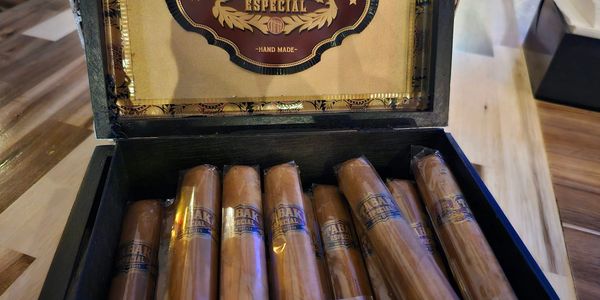 Open box of cigars on a wooden table.