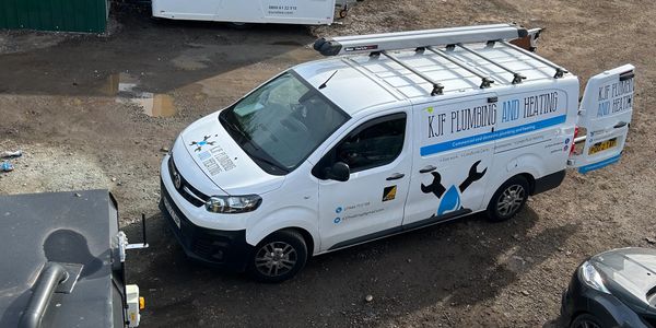 White plumbing and heating service van with ladder on top.