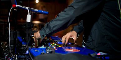 DJ Jon performing on turntables at a live event, delivering professional DJ services seamlessly.