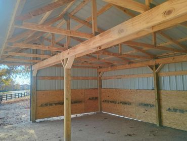 Interior of a wooden and metal framed shed with plywood lower walls.