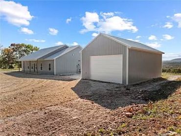 Modern metal house and garage under a blue sky.