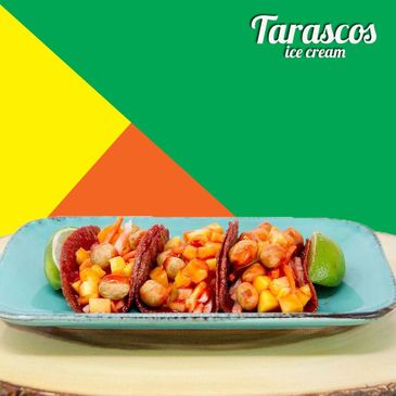 Colorful tacos with fruit and nuts on a blue plate, lime wedges on the side.
