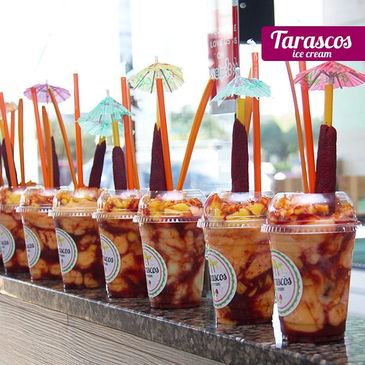 Colorful fruit cups with straws and umbrellas from Tarascos ice cream.