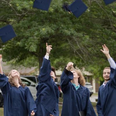 Picture of graduating Seniors from the Oaks throwing their caps.