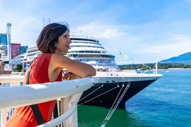 A luxury yacht in port with a guest gazing out at the Islands of French Polynesia.
