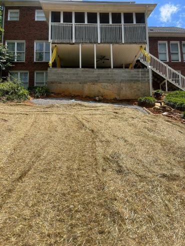 Backyard of a brick house with a new retaining wall.