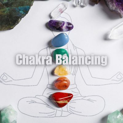 Colored chakra stones aligned on a meditation drawing with 'Chakra Balancing' text.