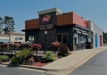 Dairy Queen Grill & Chill restaurant with outdoor seating and flower decorations.