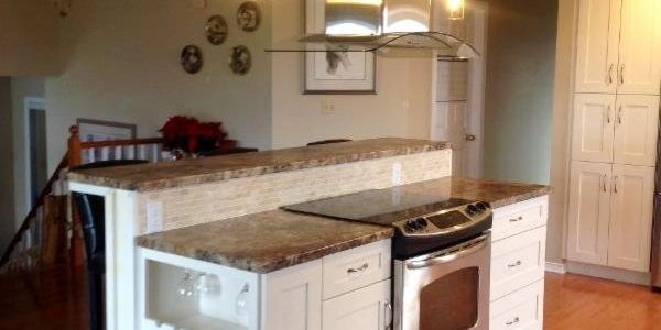 Island with custom range hood by Design by Angela