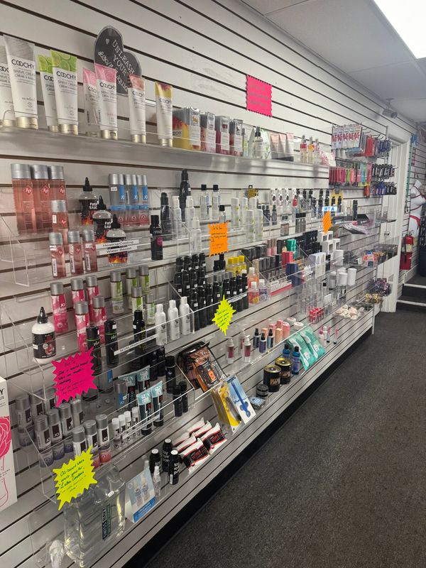 A well-organized retail shelf displays various personal care and cosmetic products with colorful informational tags.