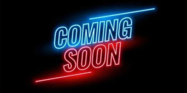 Neon sign displaying 'COMING SOON' in blue and red light against black.