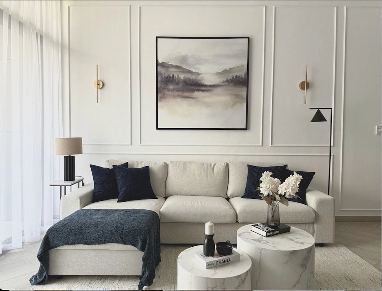 Elegant minimalist living room with beige sofa and marble tables.