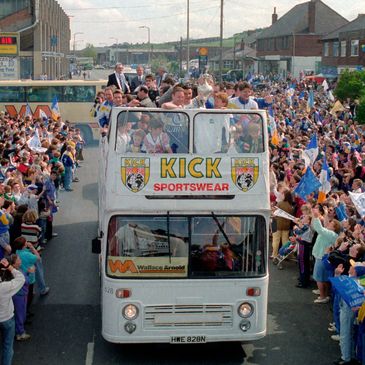 Sports team celebration parade on an open-top bus.