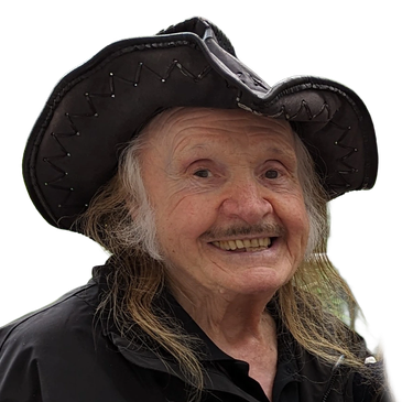 Elderly man wearing a black cowboy hat and smiling.