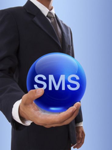 Businessman holding a blue sphere with SMS text.
