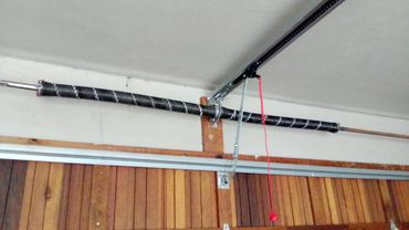 Garage door torsion spring and opener mechanism setup.