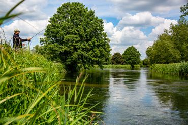 Man fly fishing on the river Test in Hampshire holding fly rod
