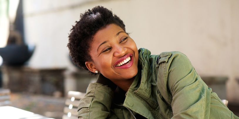 A girl smiling while sitting on a chair