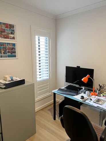 A home office fitted with plantation shutters offering clean lines and focused light.