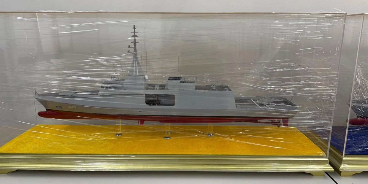 Model of a naval ship in a protective display case.