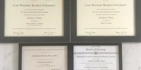 Four framed nursing certificates and licenses on a wall.