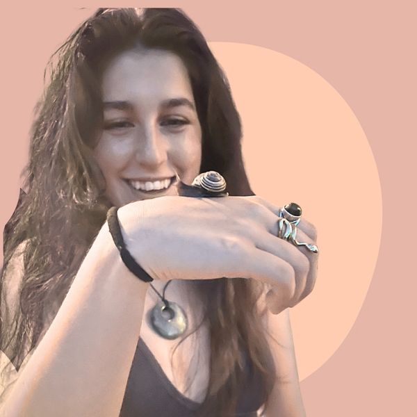 Girl smiling with snail on her hand.