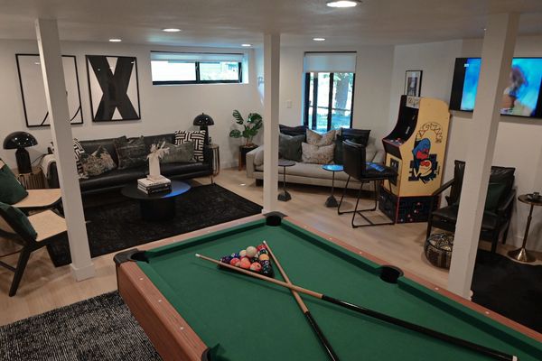Game room with a pool table, pacman arcade game, and living space.