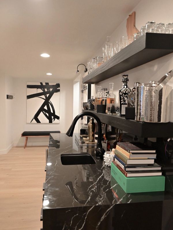 A black marble wet bar stocked with accessories