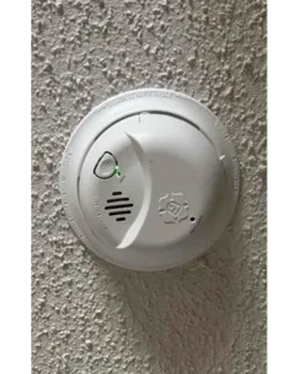 A smoke detector installed on a ceiling.