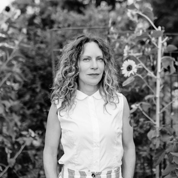 Woman with curly hair in a garden.