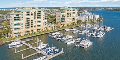Marina with yachts and waterfront condos on a sunny day.