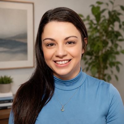 Smiling woman with long dark hair in a blue top.
