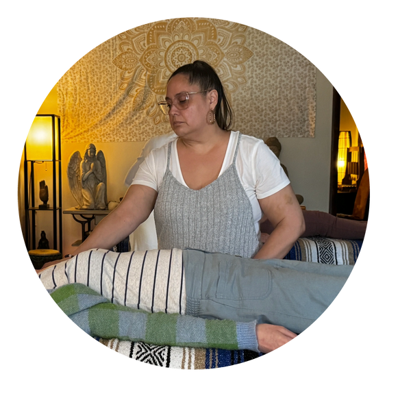 Therapist performing healing or massage on a person lying down.