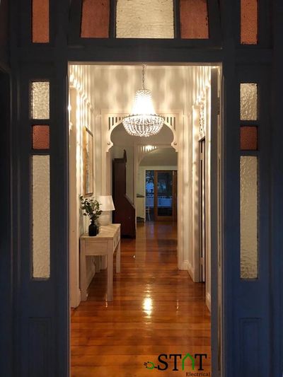 Elegant hallway with wooden floor and chandelier.