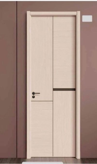 Minimalist beige wooden door with black handle on brown wall.