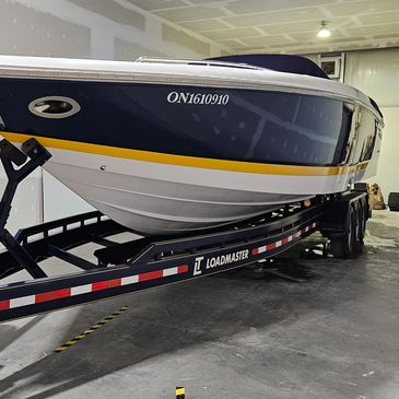 Exterior of a large boat freshly washed and waxed sitting on a polished trailer.